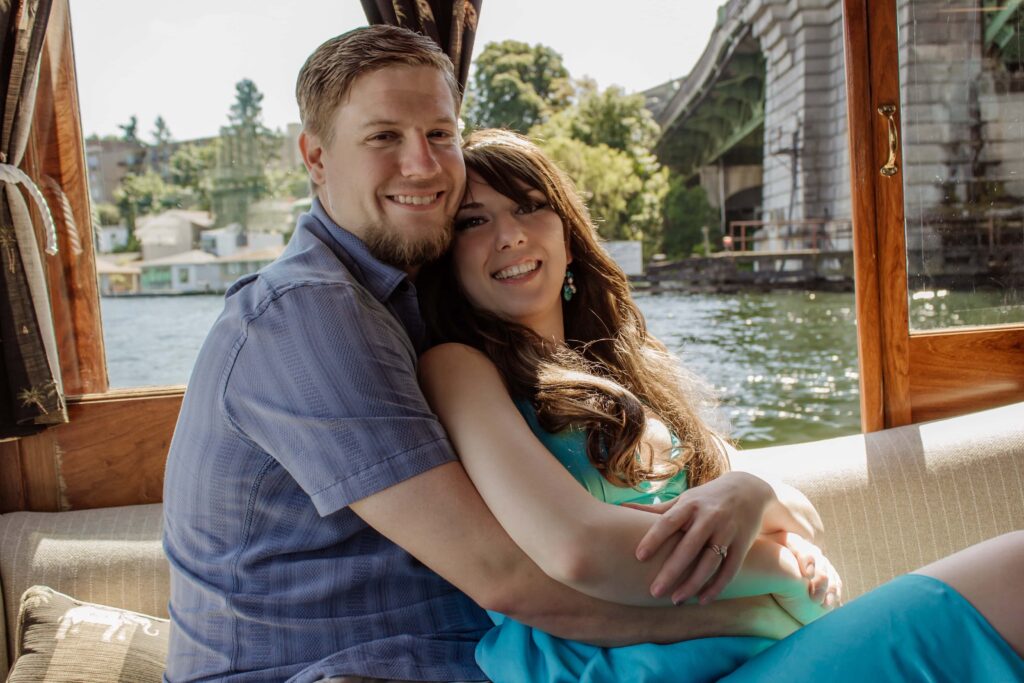 Elizabeth and Zack's original elopement on a boat on Lake Union in Seattle Zack Kissing Elizabeth's hand ofer the water ez elopements beginning