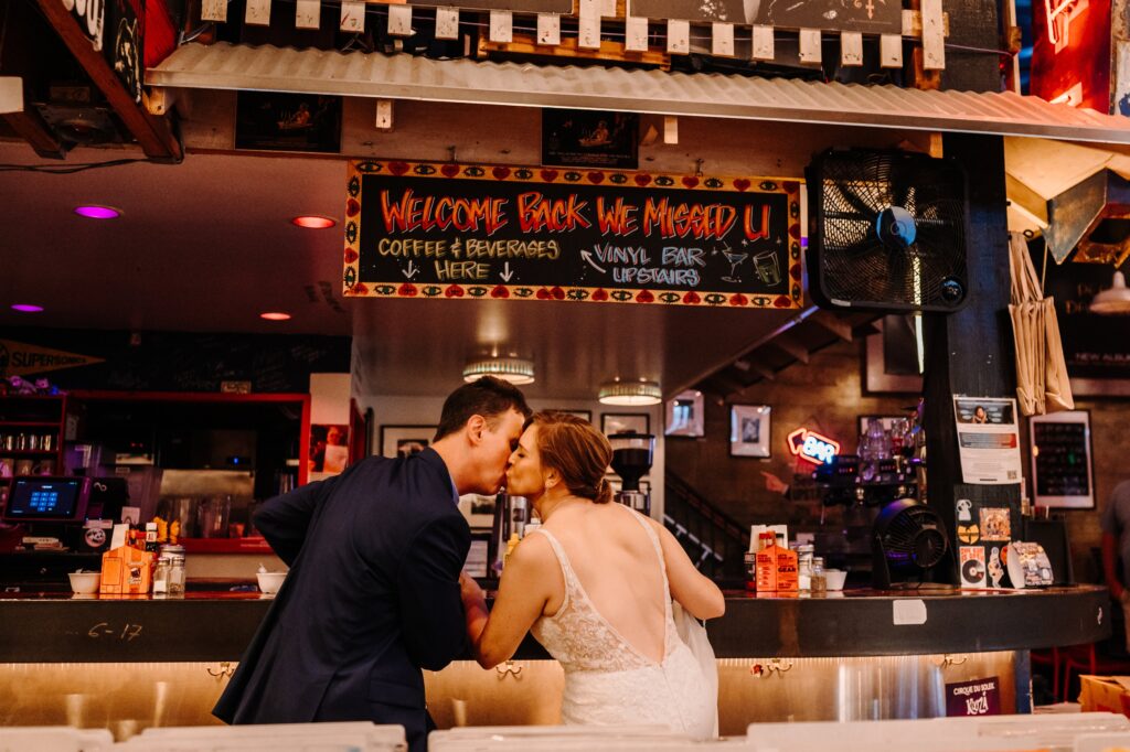 Bride and groom dining in a retro bar before their elopement.