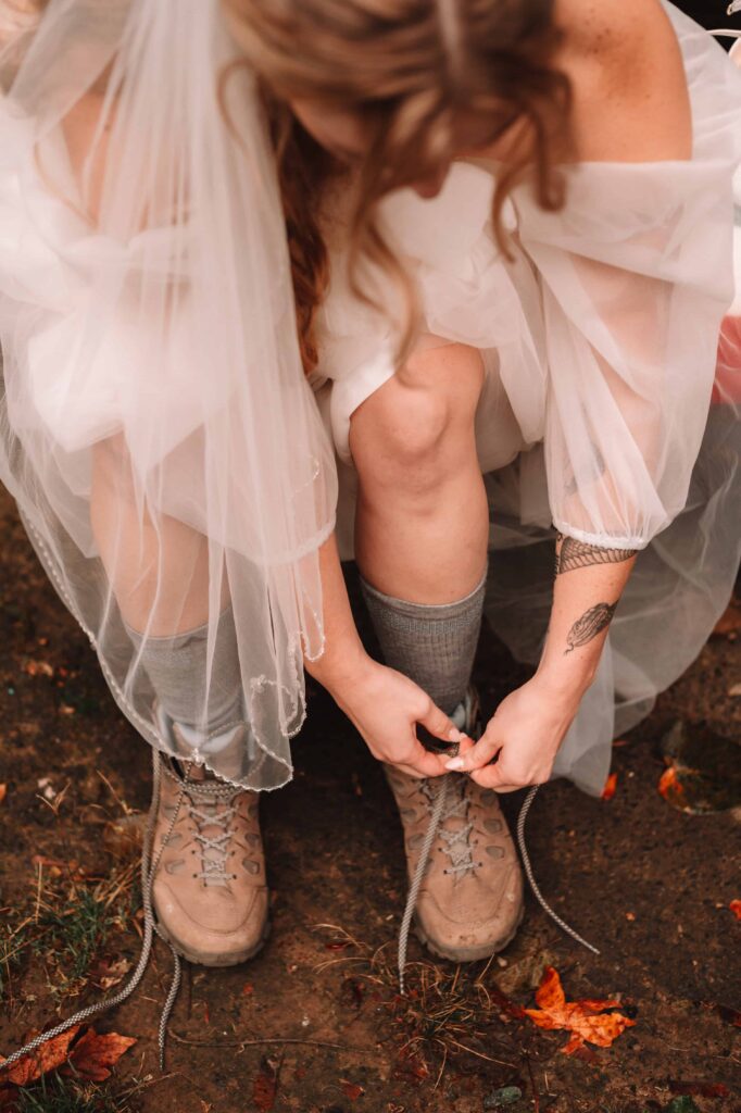 Bride lacing up her hiking boots for her adventure elopement.
