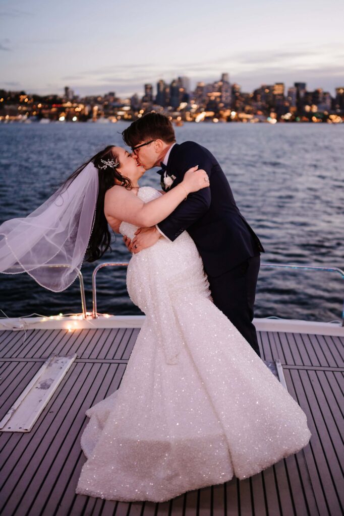 Newlywed couple share a dip kiss after exchanging their vows on a yacht.