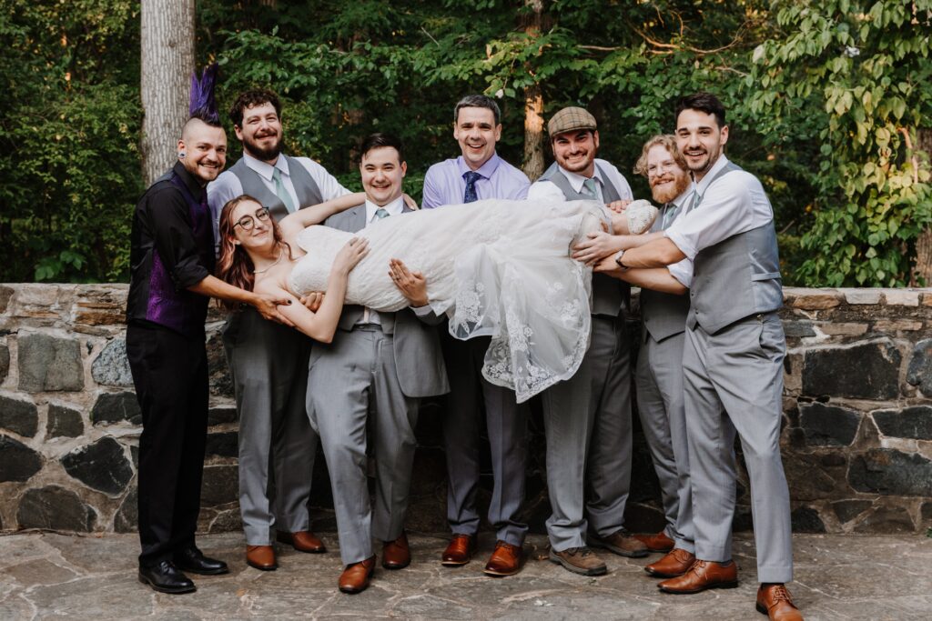 bride being held by the groom and best men after ceremony