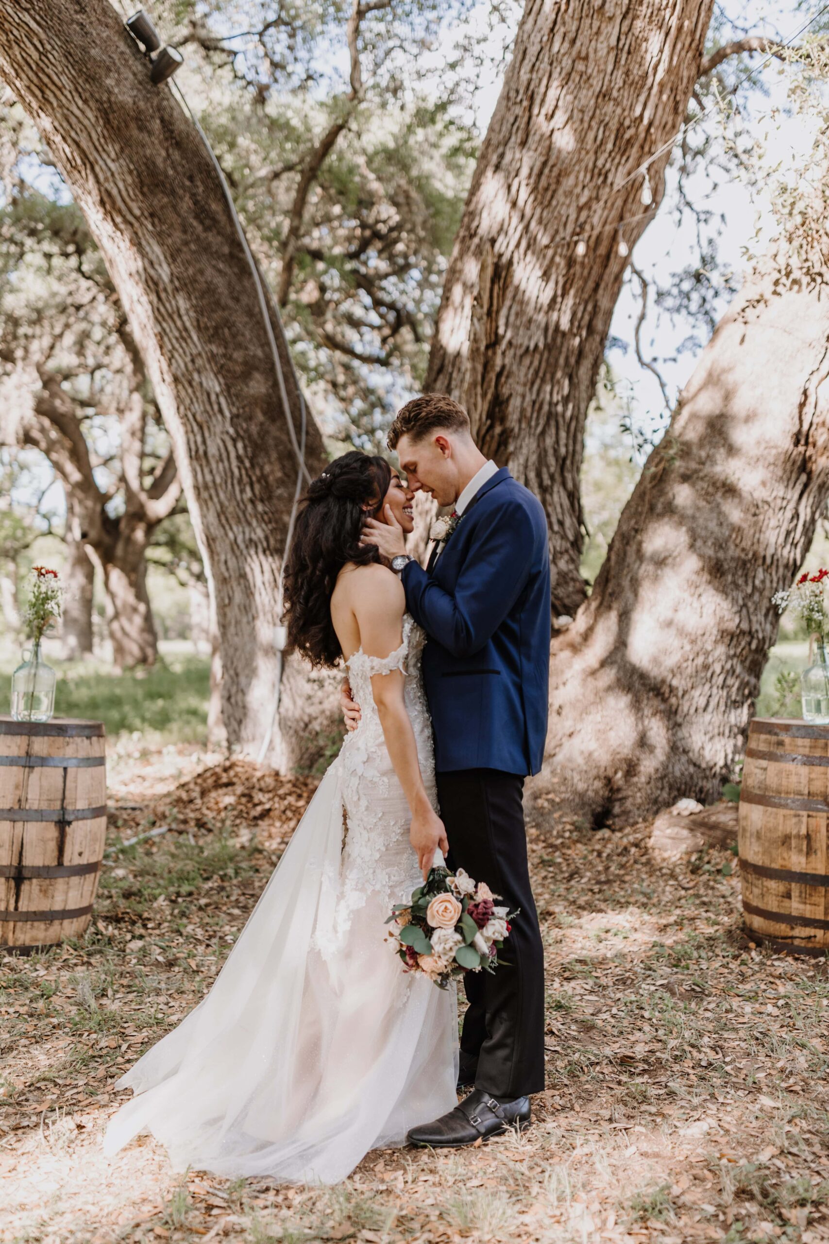 Newlyweds embrace under the big old tree.