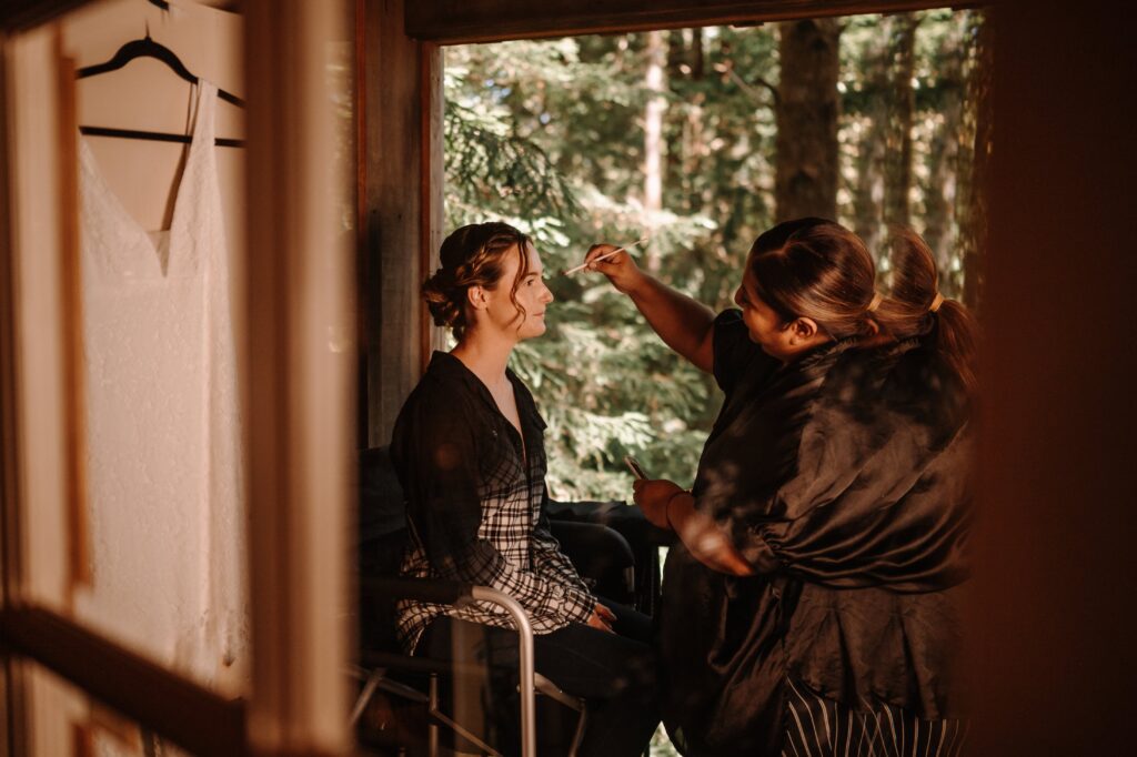 Bride to be getting ready with a hair and make up artist.