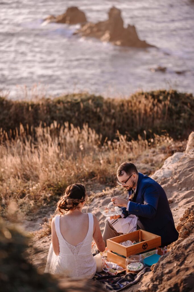 Newlyweds enjoy a beach side picnic.