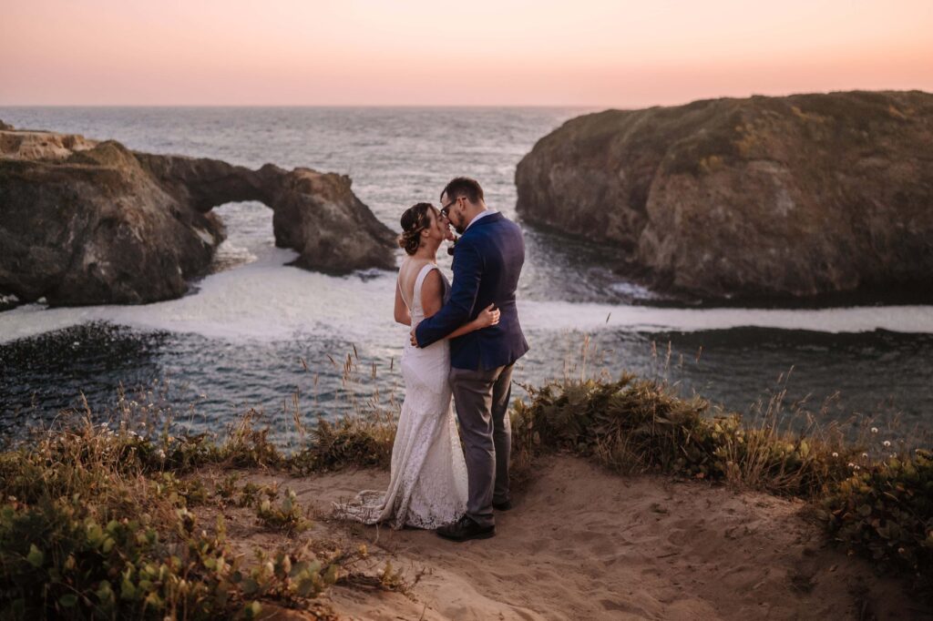 Newlyweds share a kiss overlooking the Pacific Ocean during their Redwoods Elopement.