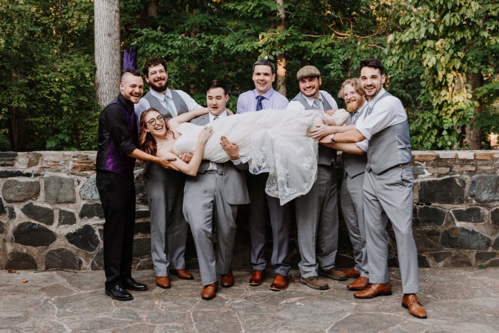 The groom and his crew hold up the bride.