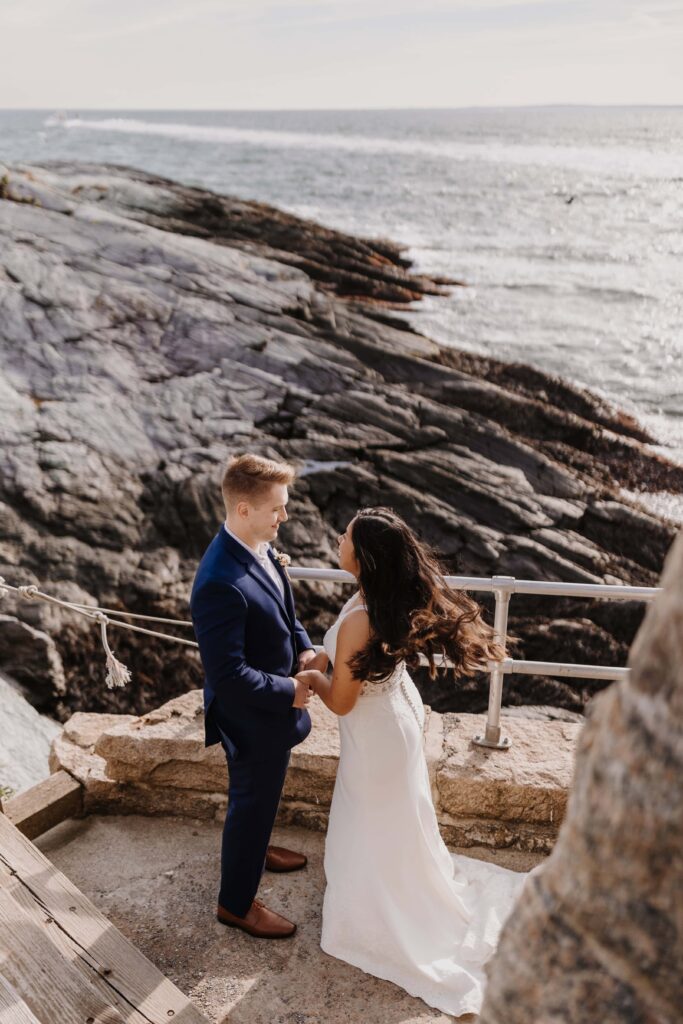 Newlywed couple looking out over the Rhode Island coast.