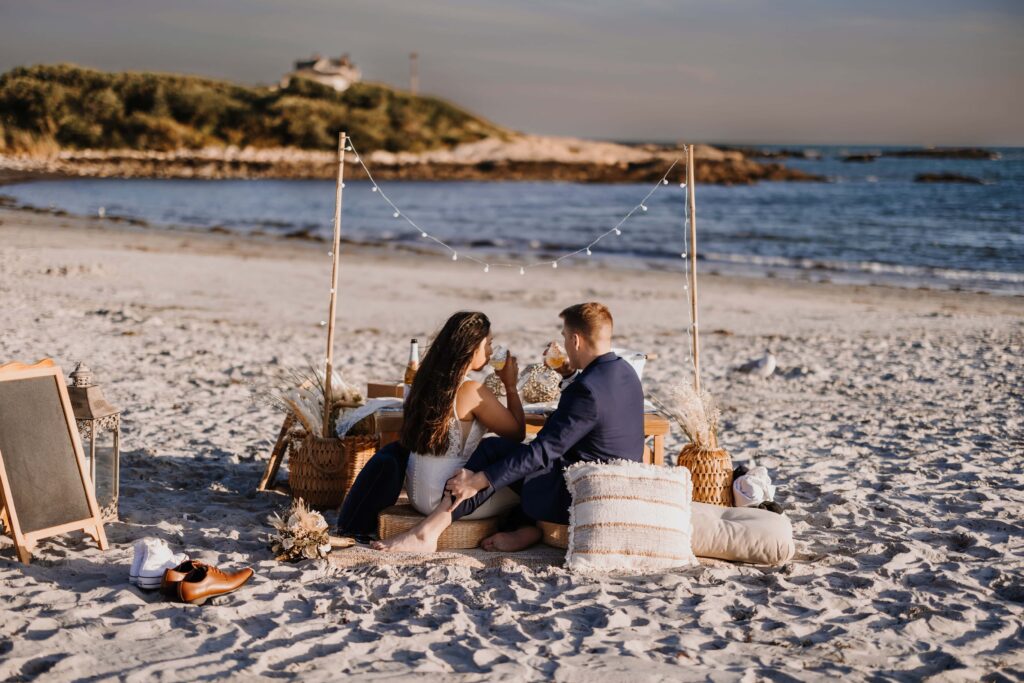 Newlywed couple enjoying their intimate elopement picnic on the the Rhode Island coast.