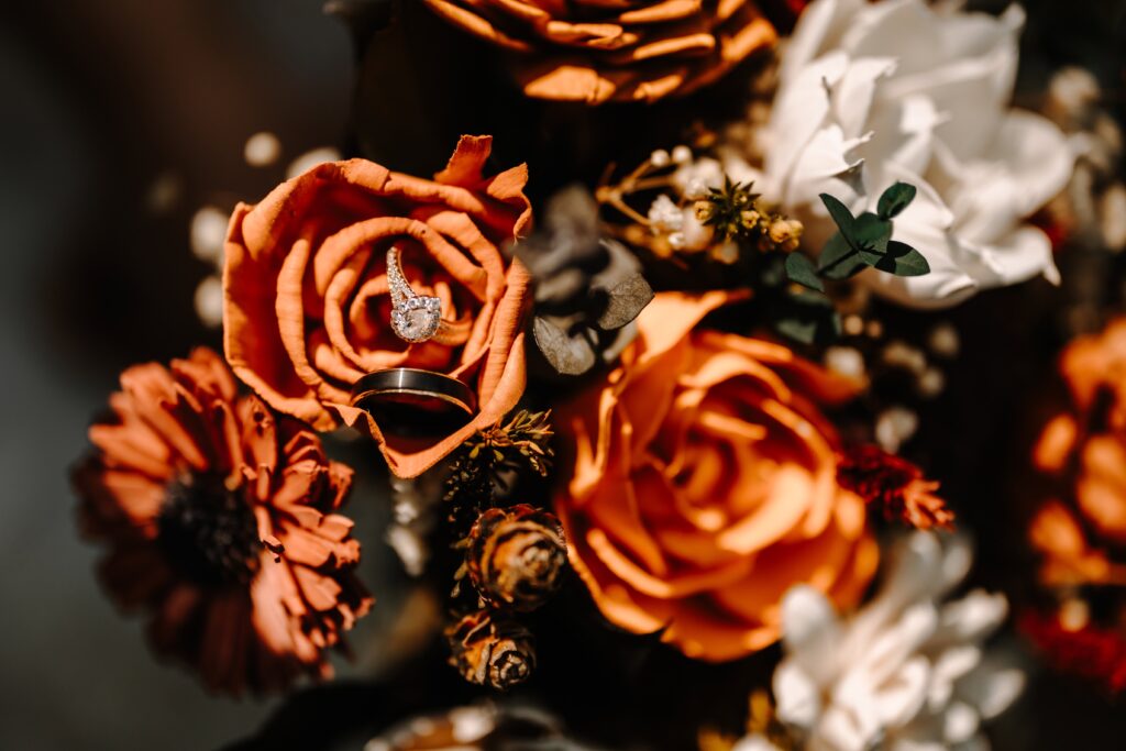 Overview of a sola wood bouquet made with orange, ivory, tan, white and natural wood flowers.