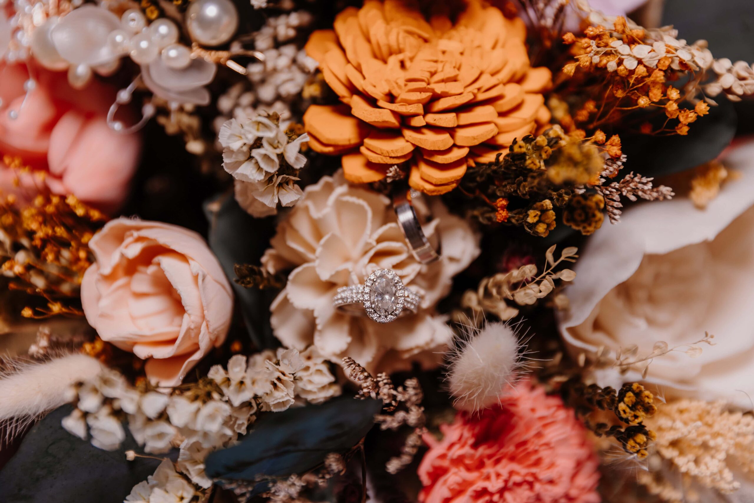 Overview of a bouquet made with peach, ivory, and orange wood flowers.