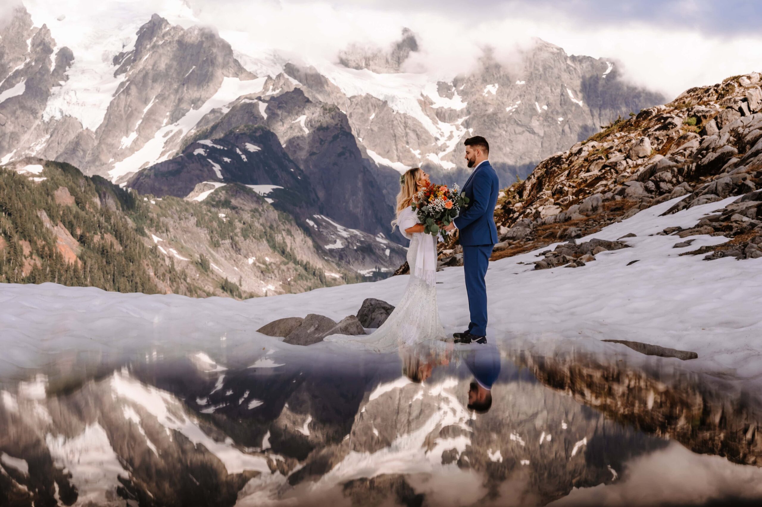 Bride and Groom atop a snowy mountaintop.