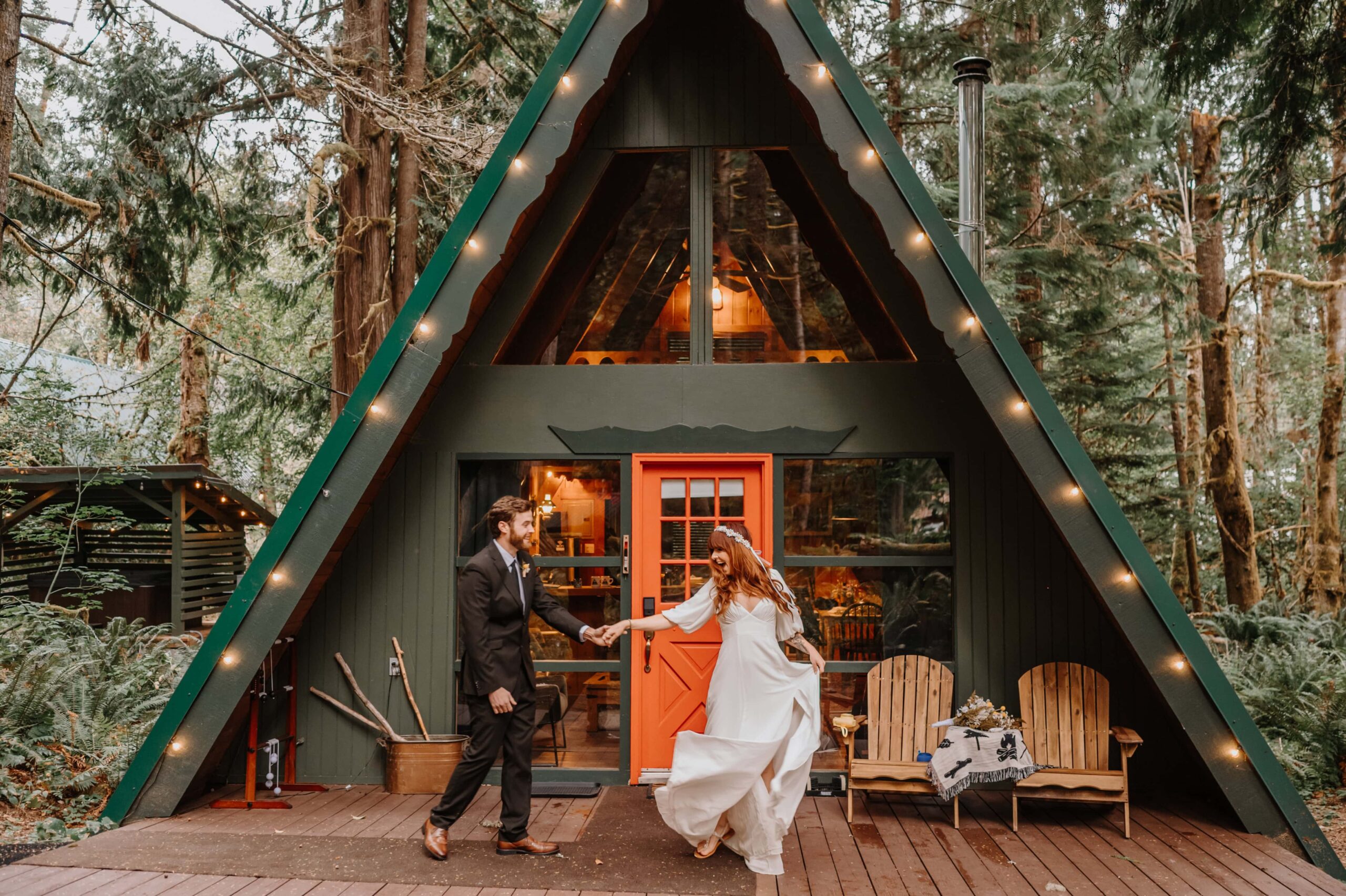 Bride and Groom dance before a beautiful A-frame cabin.
