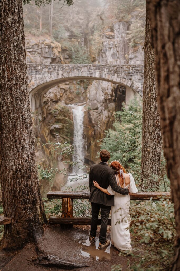Couple embracing while looking at a gorgeous waterfall.
