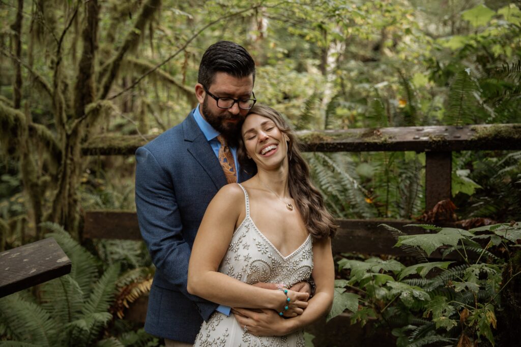 Bride and Groom share a laugh and embrace in the Quinault Rainforest during their National Park elopement.