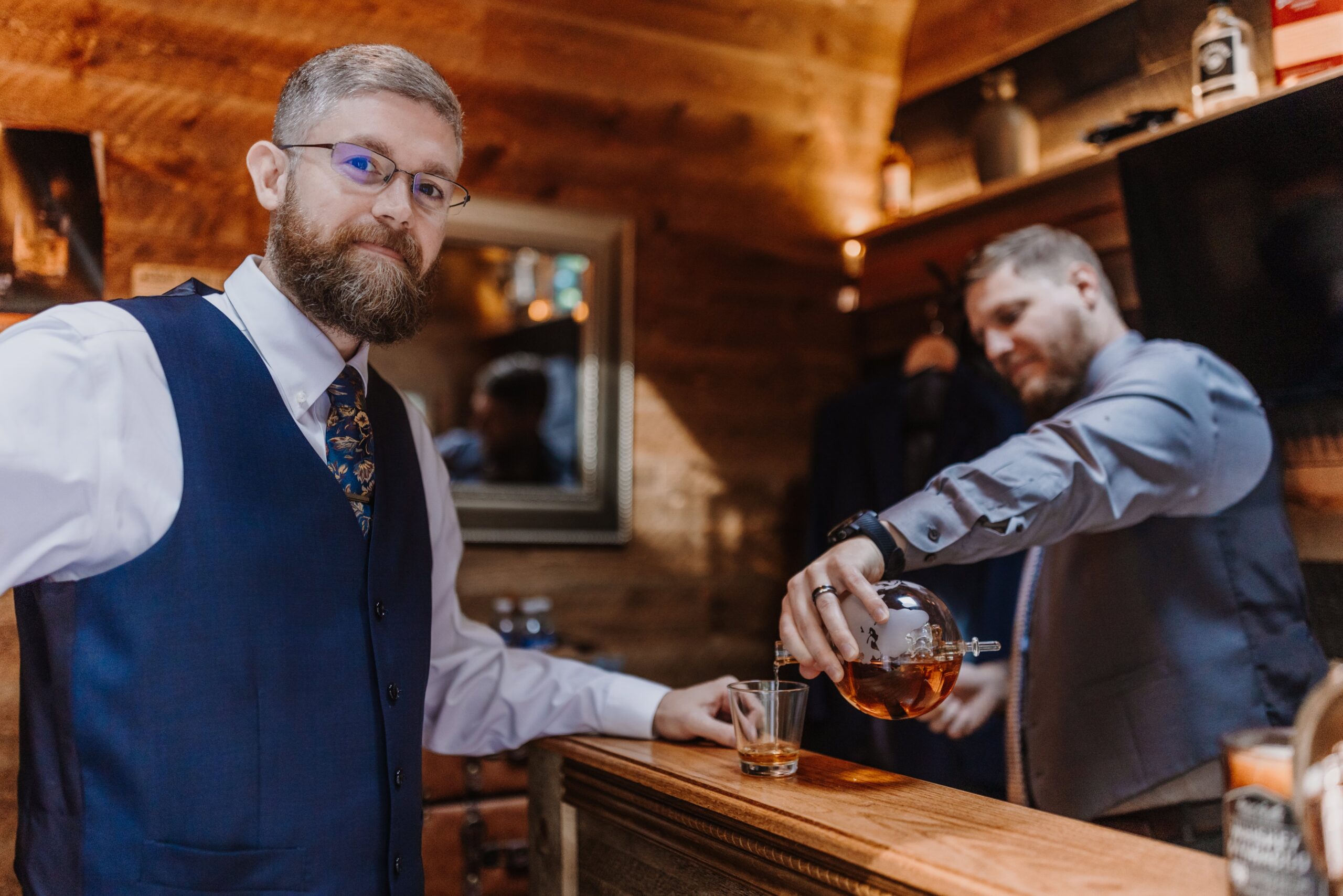 A groom and officiant share a drink in our Groom's Shed.