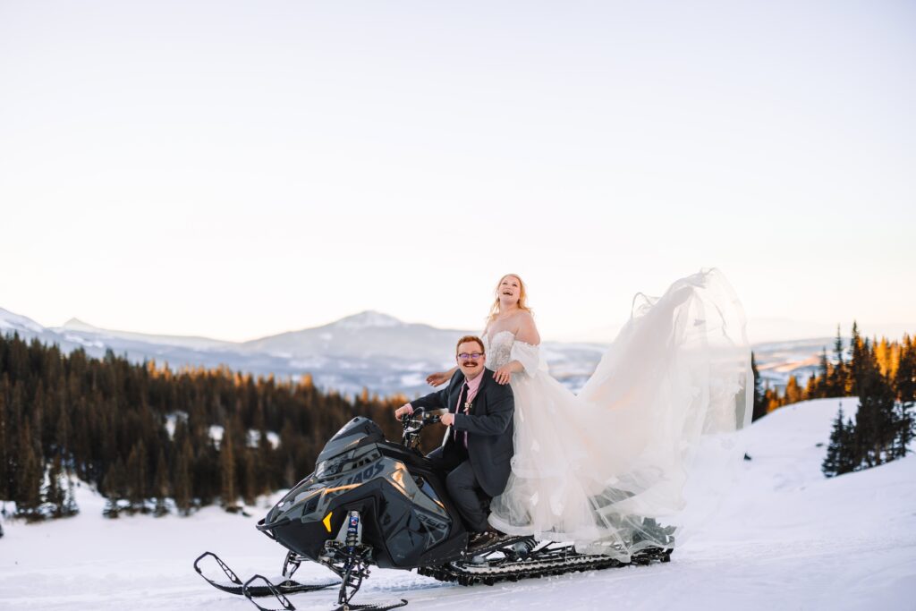 Bride and Groom snowmobile through their Colorado Elopement Location.
