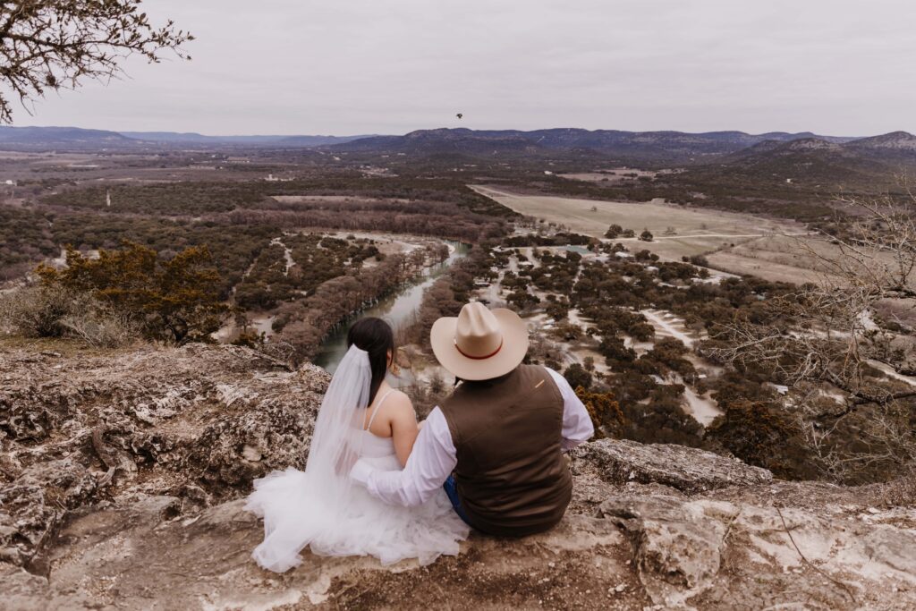 Garner-State-Park-TX-camping-Elopement-small wedding venue bride and groom seating on a mountain with river views_www.ezelopements.com