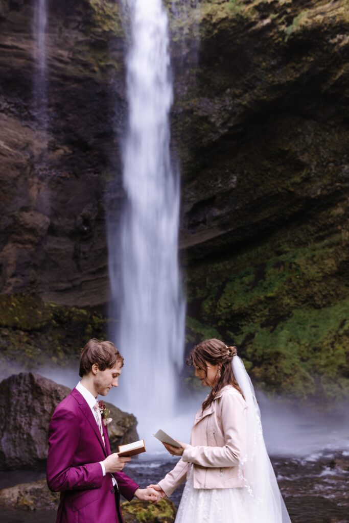 Bride and Groom exchange letters in front of a waterfall.