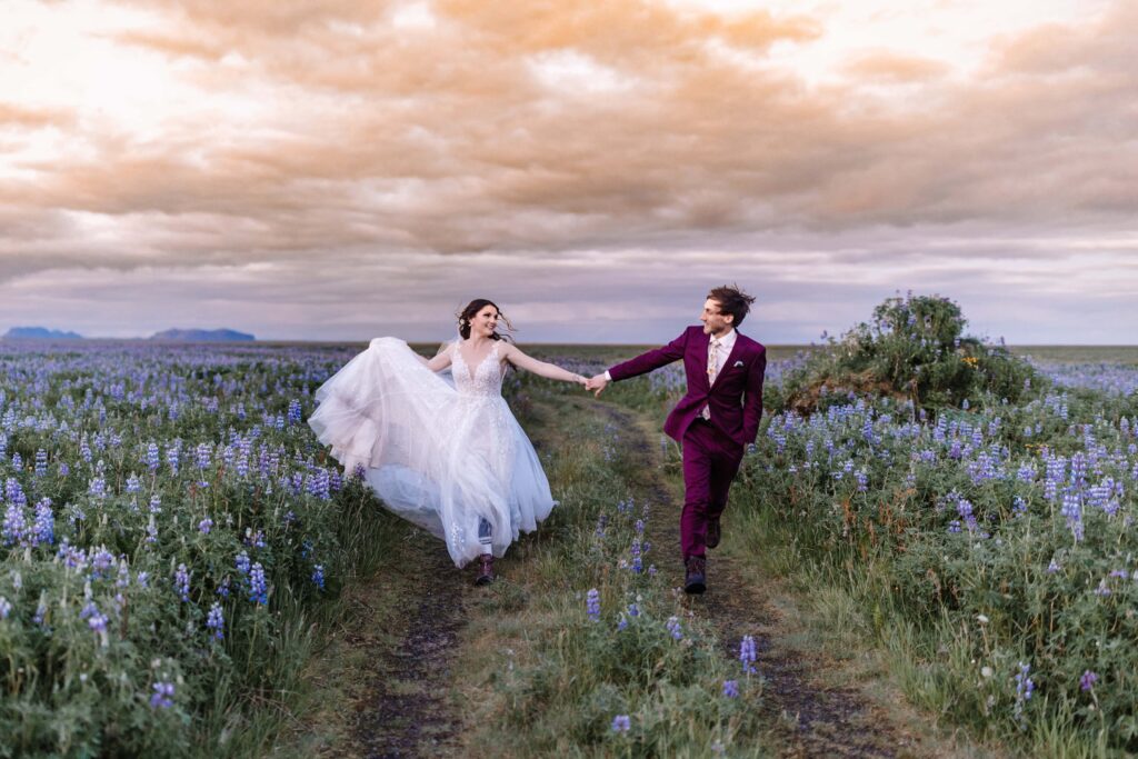 Bride and groom frolicking in a field.