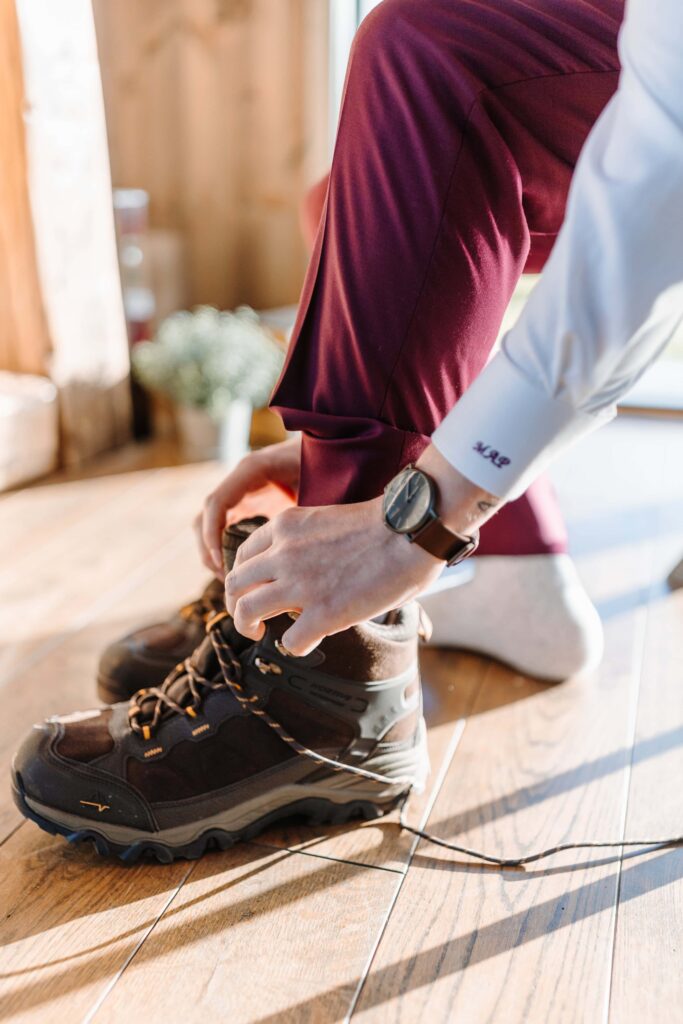 The groom lacing up his hiking boots.