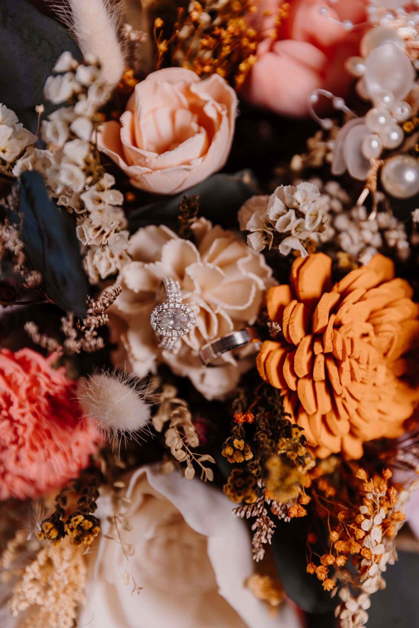 Overview of a bouquet made with peach, ivory, and orange wood flowers.