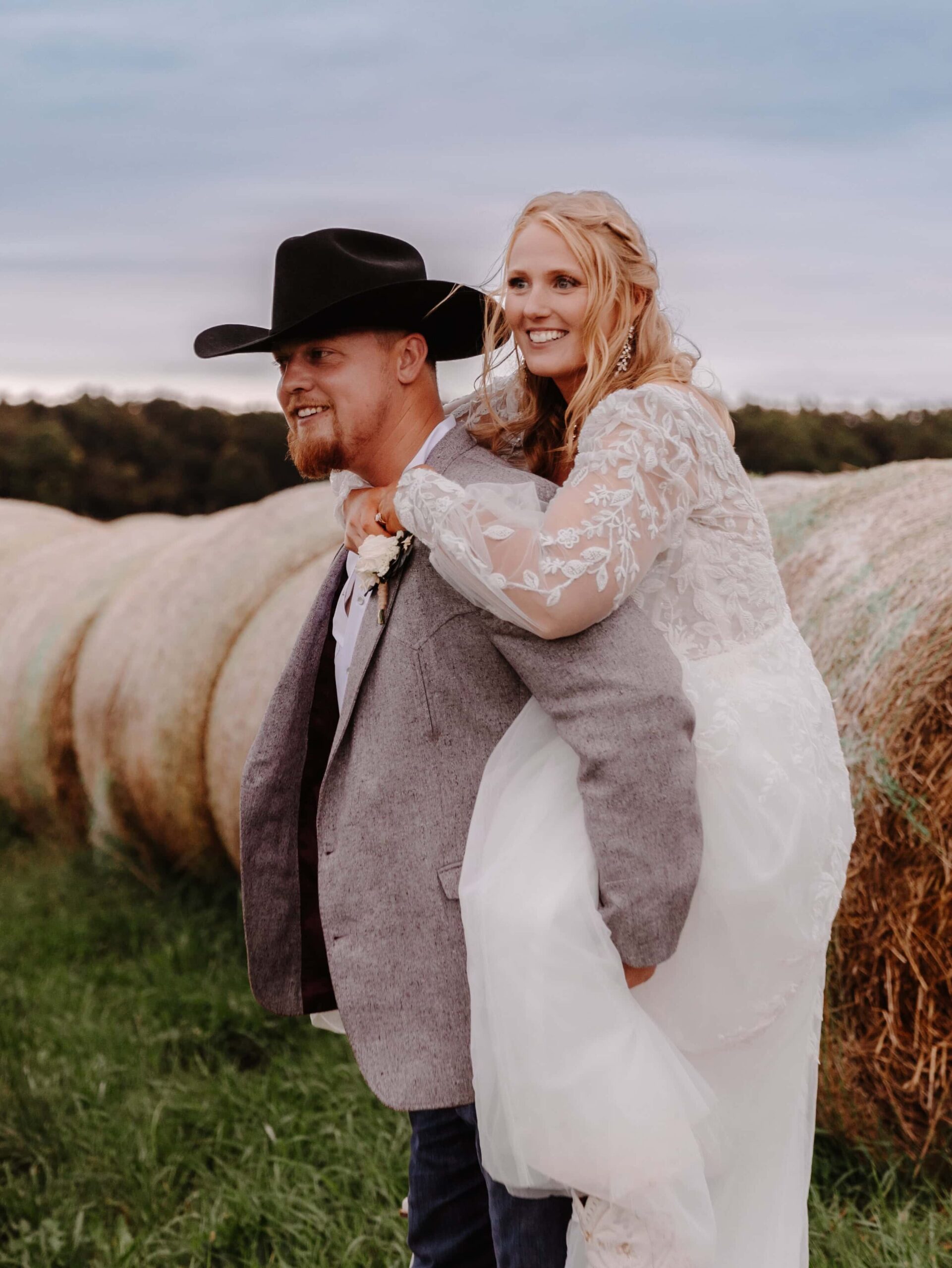A southern couple embraces in a field of hay post elopement.