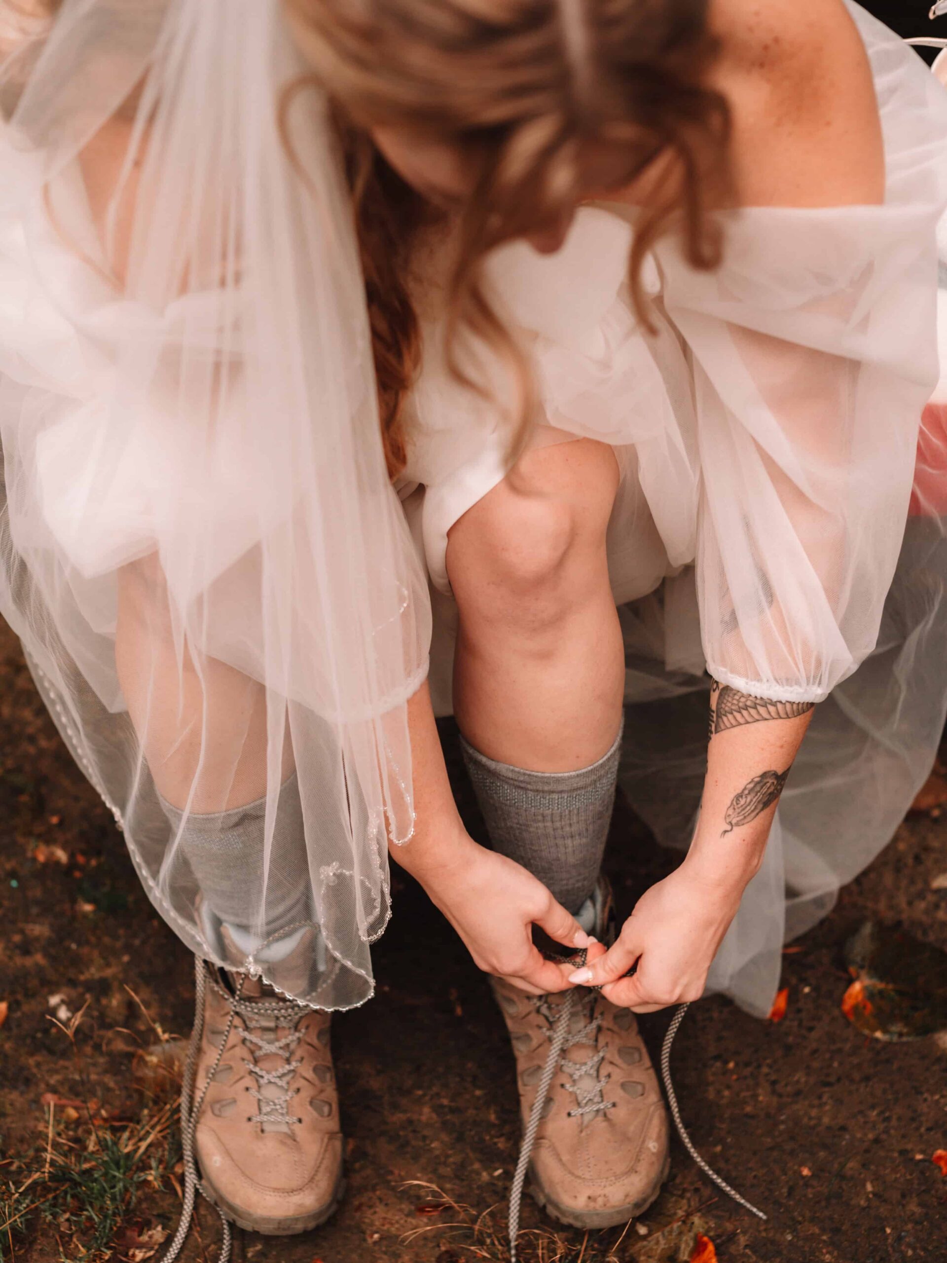 Bride lacing up her hiking boots for her adventure elopement.
