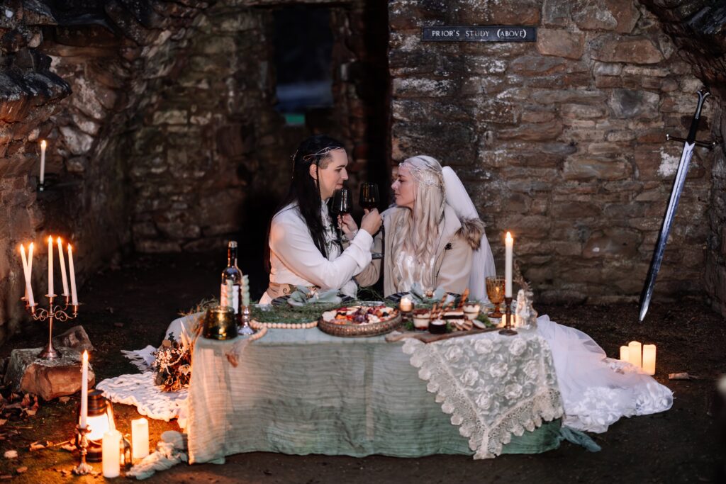Couple toast to their new union during a catacomb dining experience in the UK. 