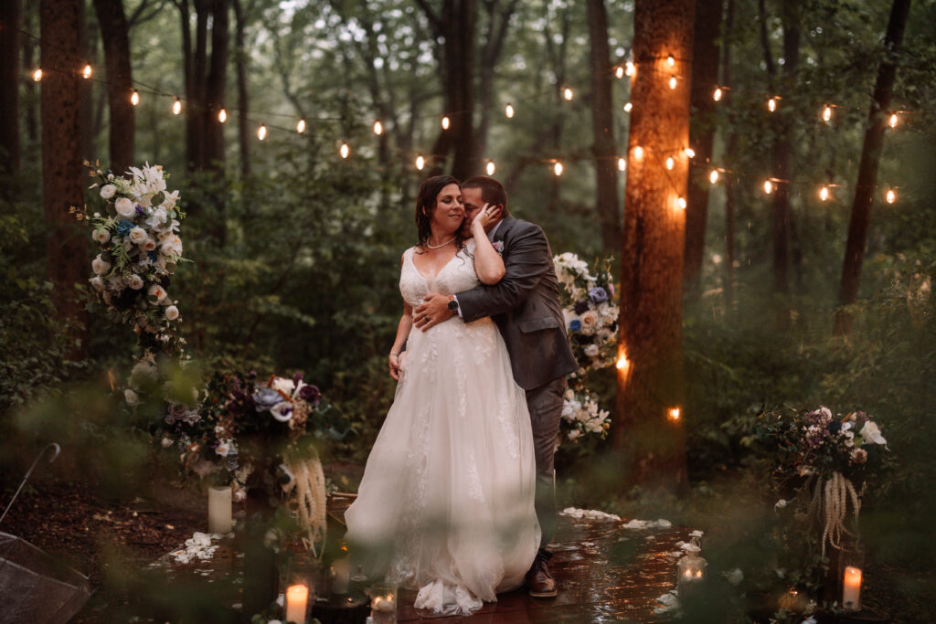 Couple embraces under the lighting of our forest platform.