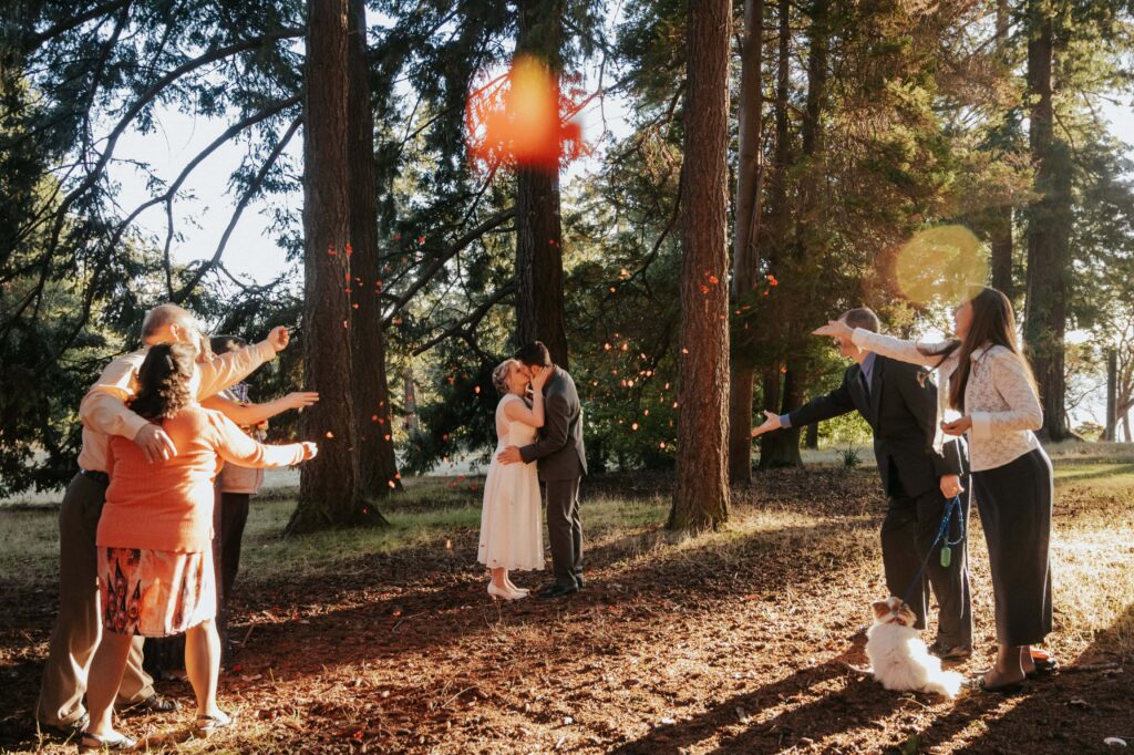 Petals re baeing tossed at the newlyweds at a simple park elopement. 