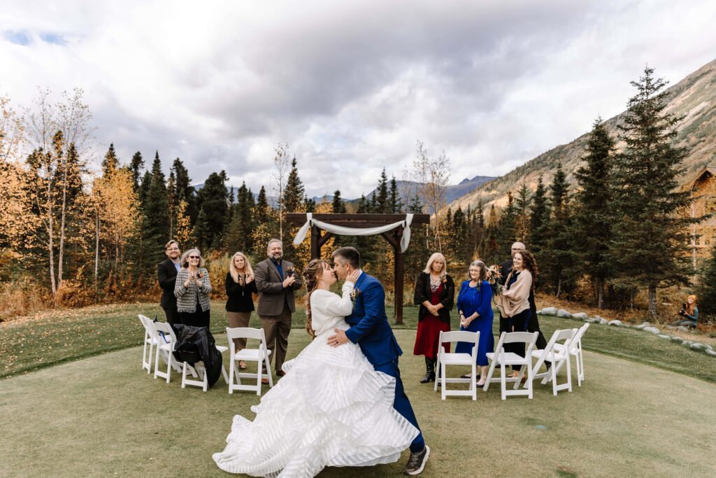 A couple sharing their first kiss at their destination micro wedding in Alaska. 