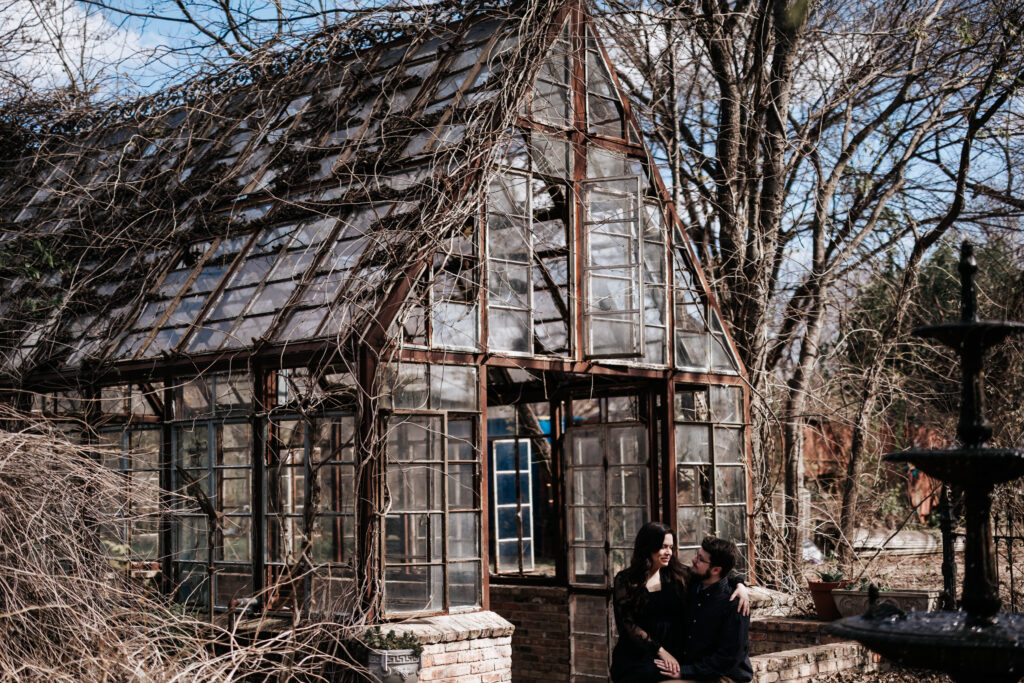 One of our lovely couples taking engagement photos in front of a unique greenhouse venue in Texas.