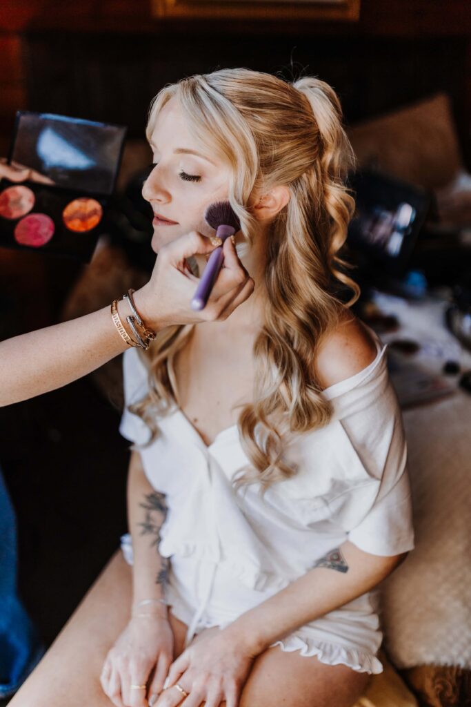 The bride getting her makeup applied by artist Summer Lynn Beauty