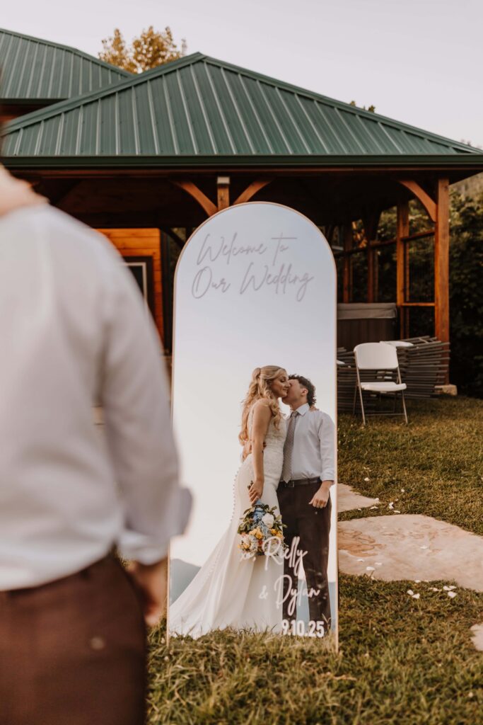 The Bride and Groom posing in front of their custom welcome mirror.