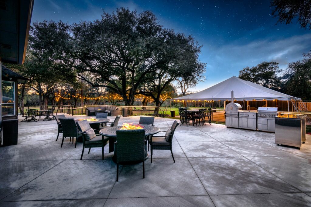 Outdoor entertainment area at Serenita Estate featuring multiple dining sets around cozy fire pit tables