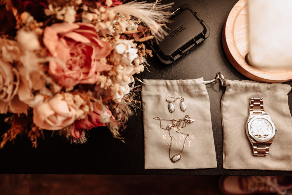 A shot of a couple's details for their wedding day. Jewelry, an heirloom watch, bouquet.